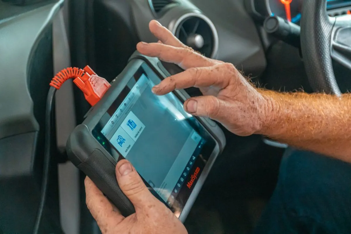 Serrurier automobile branchant une valise de diagnostic pour reprogrammer une carte de démarrage à Levallois
