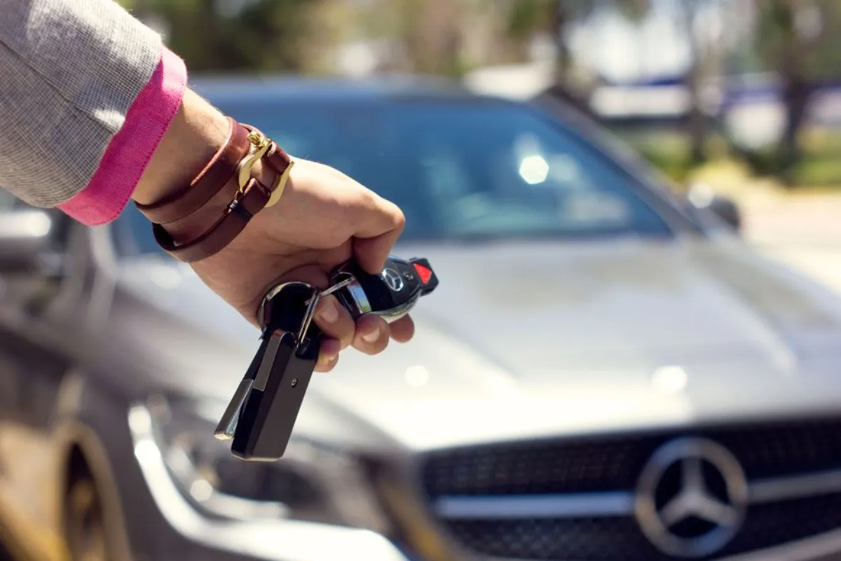 Clé de voiture mains libres et smartphone affichant une application d'antivol connecté