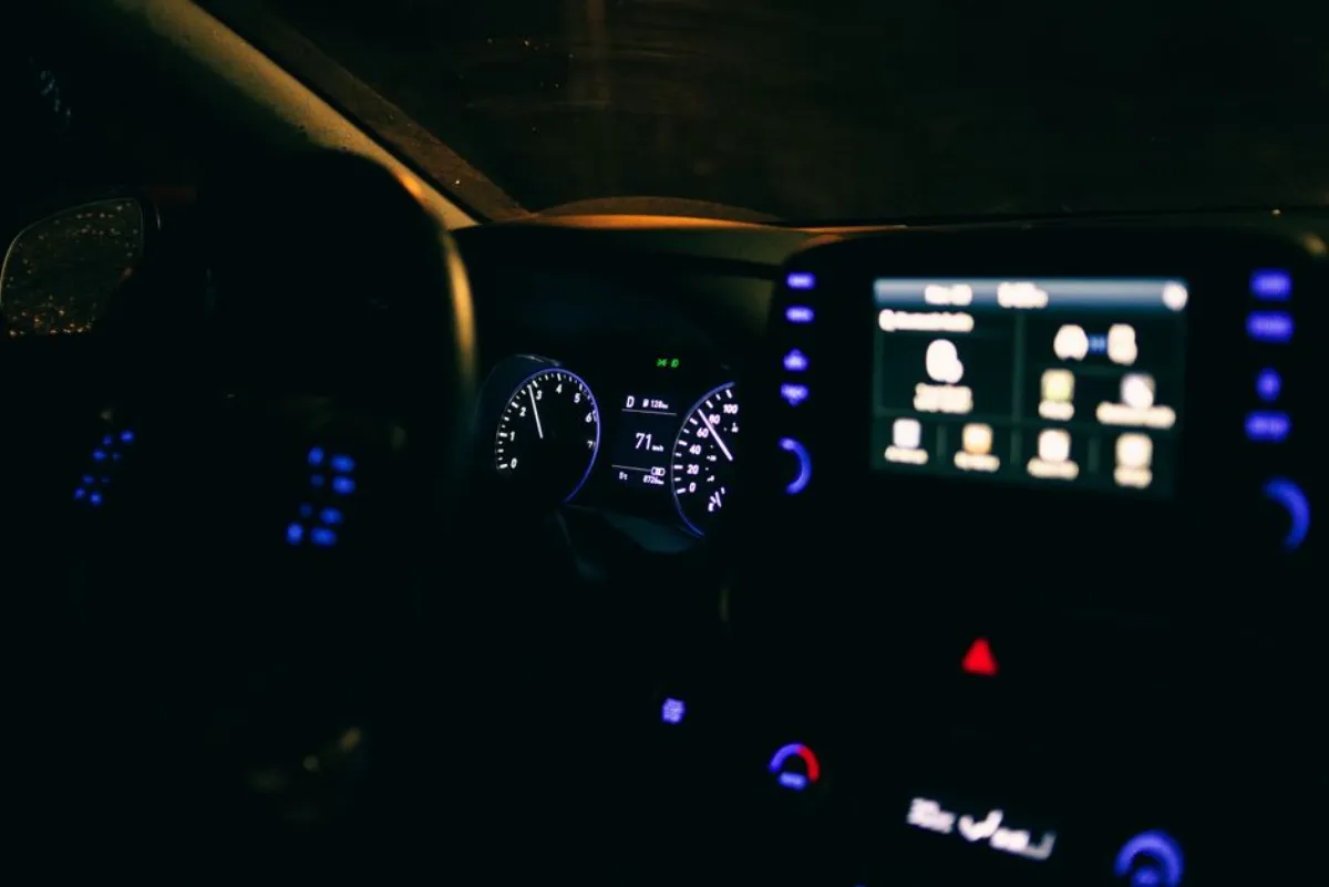 Tableau de bord d'une voiture la nuit, symbole d'antivol connecté surveillant le démarrage du véhicule
